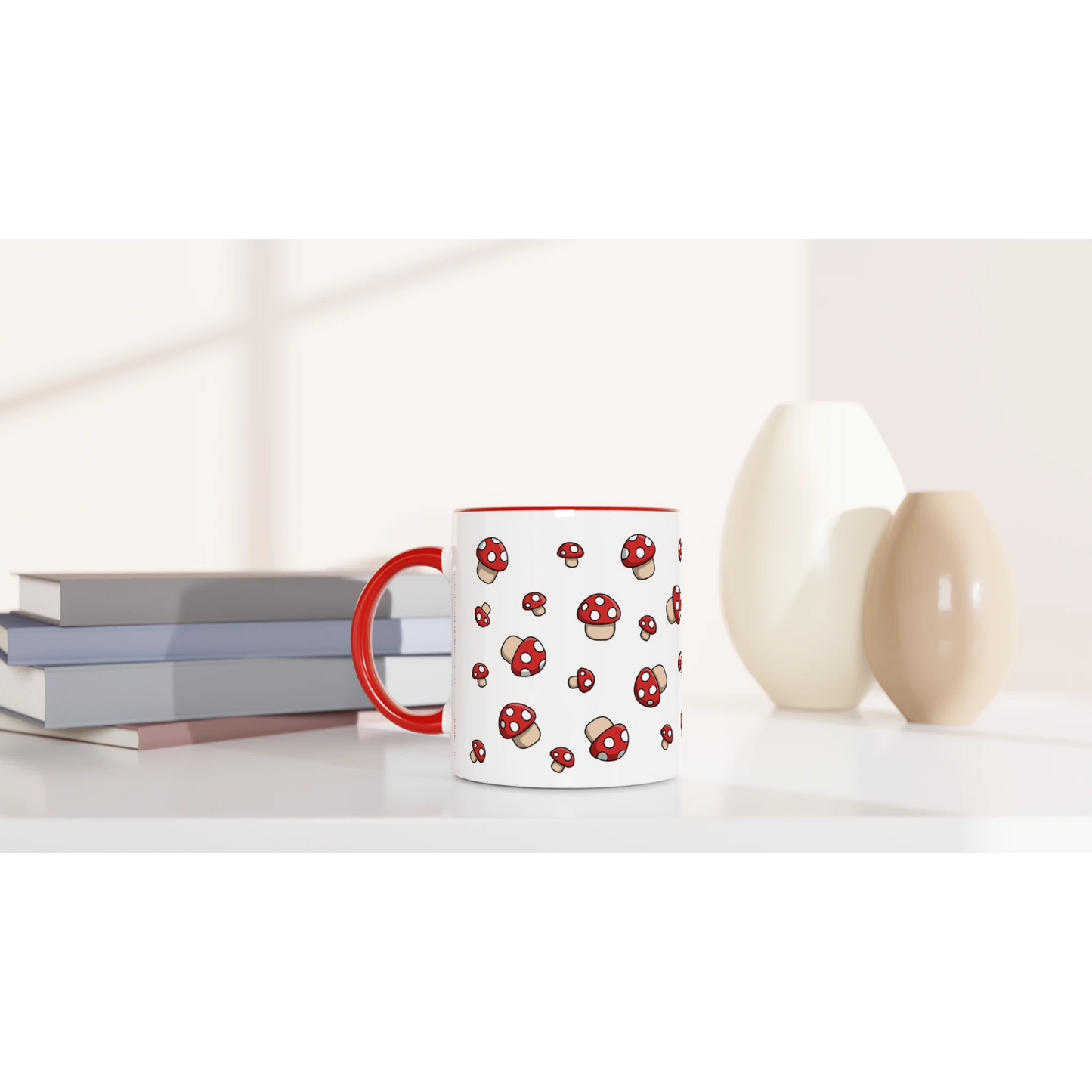 Astral Apple dish washer safe, microwave safe ceramic coffee mug in White and Red, with graphic print of lots of little red fly agaric or Amanita Muscaria mushrooms with white spots, on a desk, for the mycologist who loves mushroom coffee, tea and hot chocolate