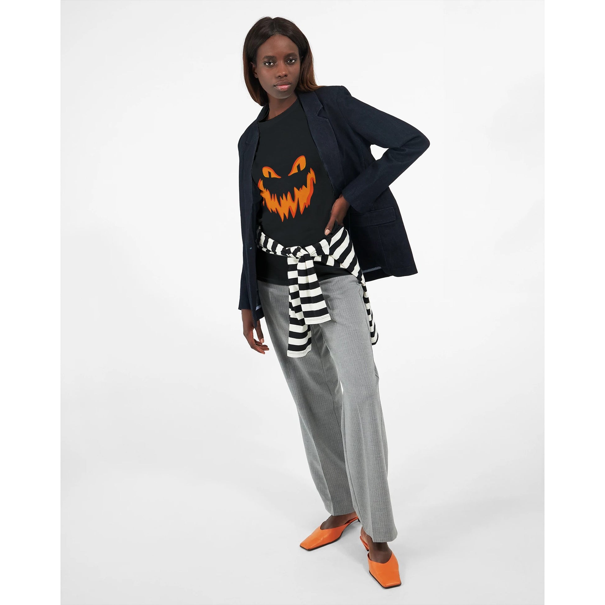 A black, long sleeved Halloween t shirt with a spooky smiling Jack o' Lantern pumpkin face worn by a woman.