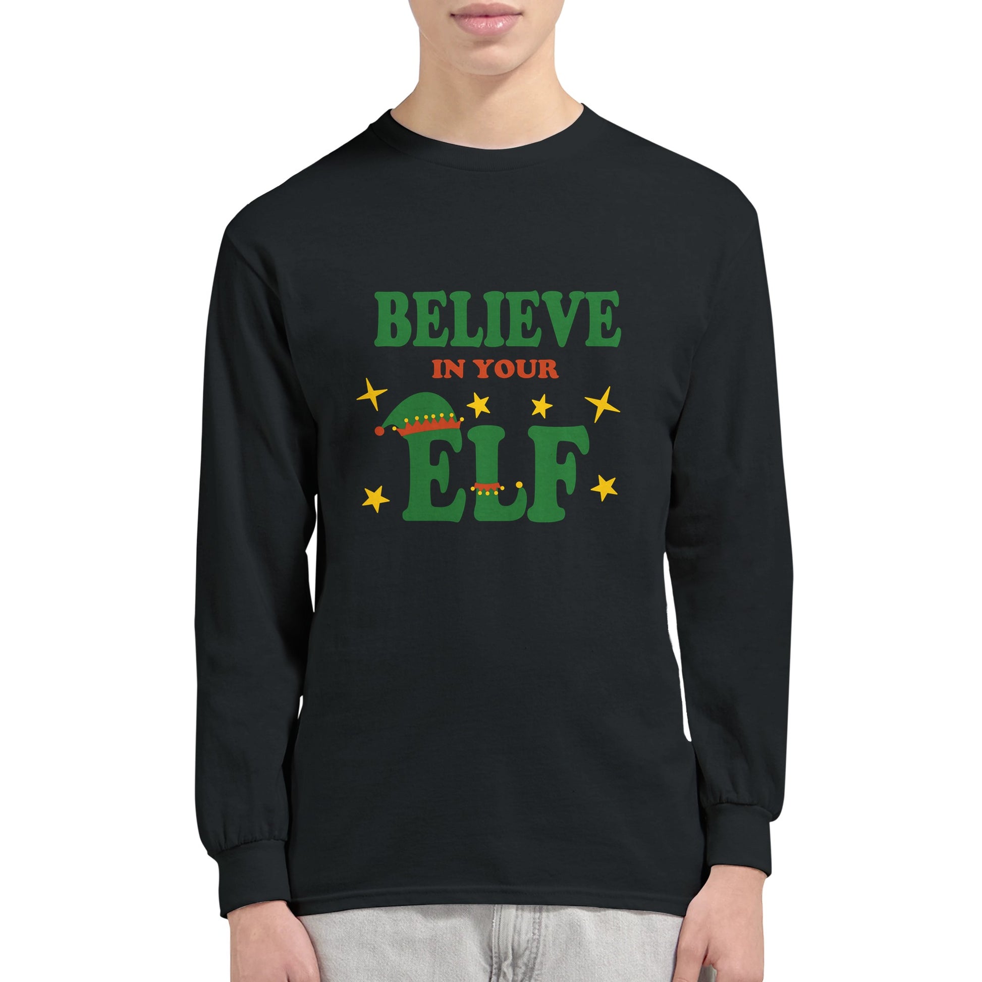 A black, long sleeved t shirt with the funny pun, "believe in your elf" worn by a man.