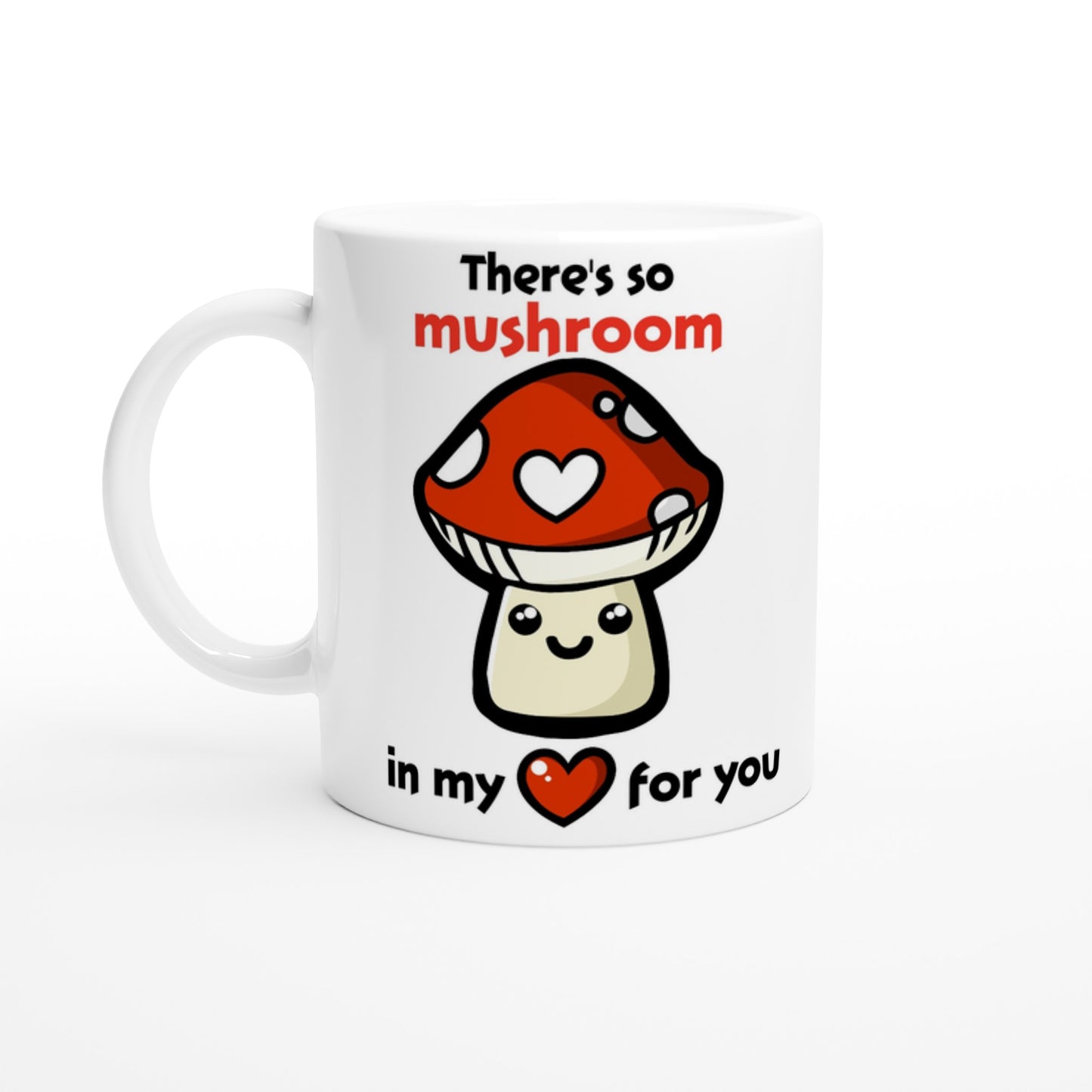 A white ceramic mug with black text saying, "There's so mushroom in my heart for you" where the word mushroom is in red and the word hear is replaced with a red heart, and there is a picture of a cute, smiling cartoon style amanita muscaria or fly agaric mushroom where one of it's white spots is a white heart.