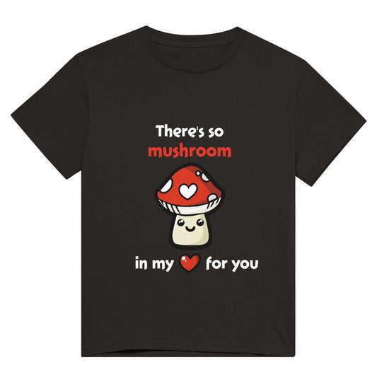 A black shirt with white text saying, "There's so mushroom in my heart for you" where the word mushroom is in red and the word hear is replaced with a red heart, and there is a picture of a cute, smiling cartoon style amanita muscaria or fly agaric mushroom where one of it's white spots is a white heart.