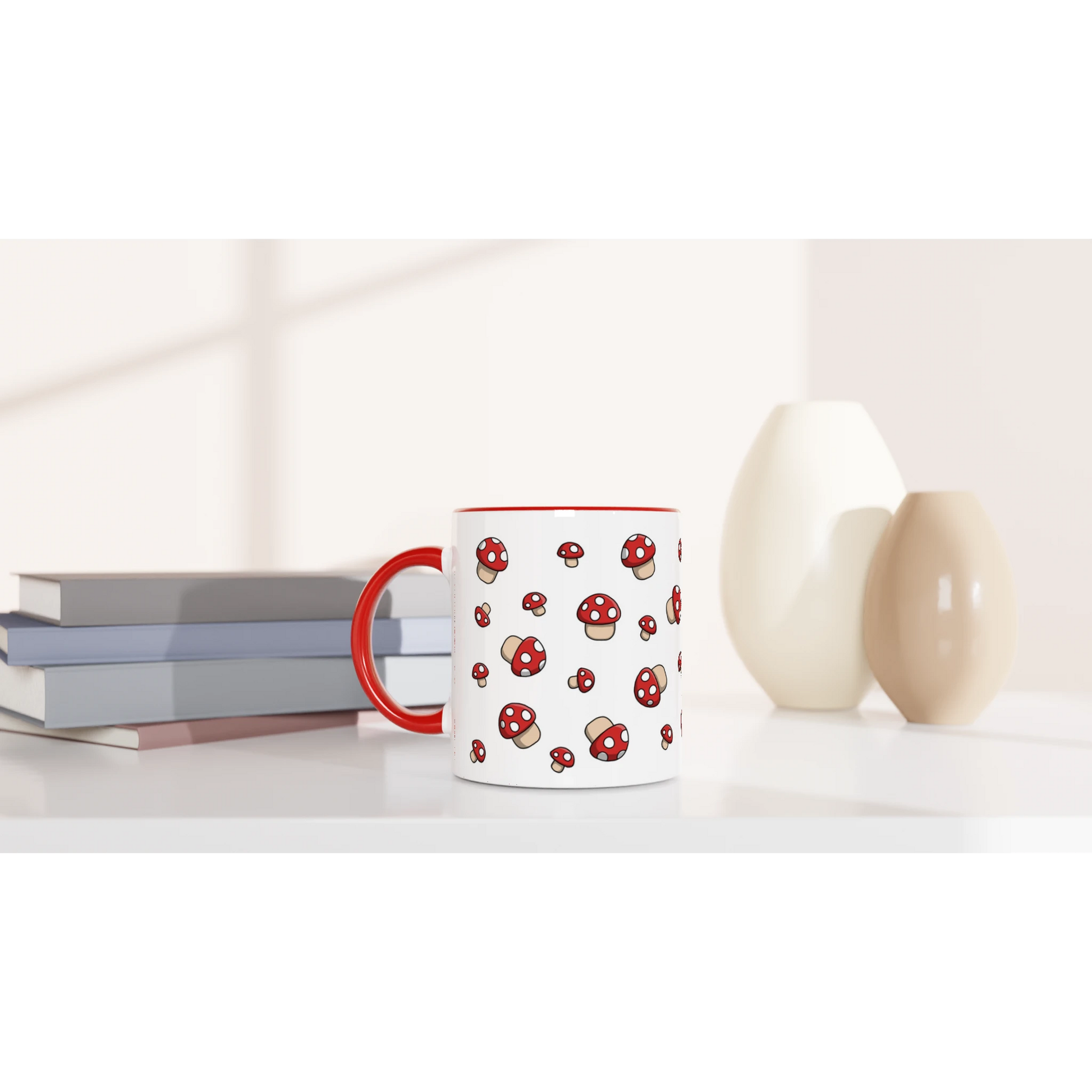 Astral Apple dish washer safe, microwave safe ceramic coffee mug in White and Red, with graphic print of lots of little red  fly agaric or Amanita Muscaria mushrooms with white spots, on a desk, for the mycologist who loves mushroom coffee, tea and hot chocolate