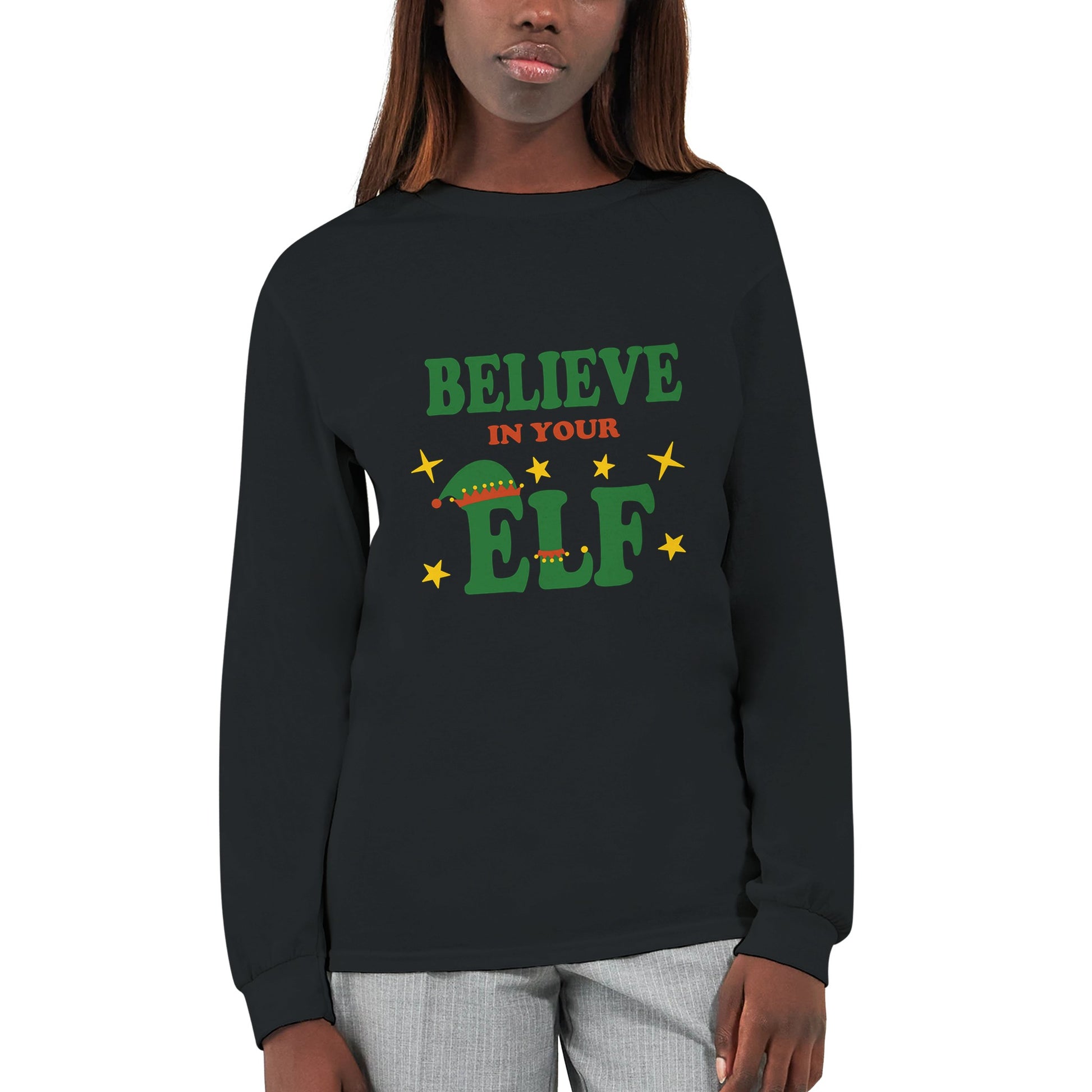 A black, long sleeved t shirt with the funny pun, "believe in your elf" worn by a woman.