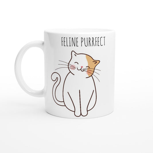 A white ceramic mug with the words "Feline purrfect" in black and a picture of a white and light brown cat smiling and sitting happily.