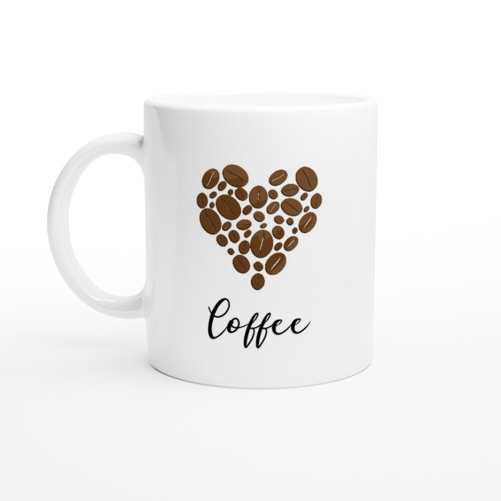 A white ceramic mug with the word "coffee" in black and a picture of a heart made out of coffee beans above it.