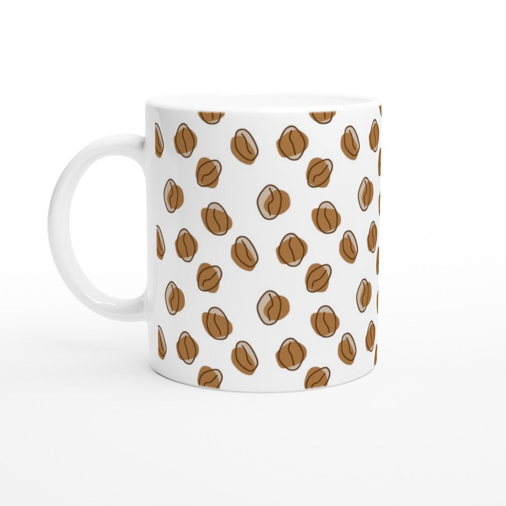 White ceramic mug with a pattern of abstract brown coffee beans all over it.