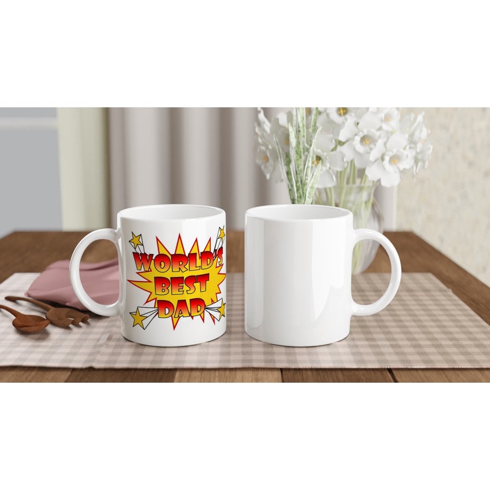 The front and back view of a white ceramic mug with the words, "world's best dad" in graded yellow and red, with a comic book style explosion in the background and yellow stars in each corner.