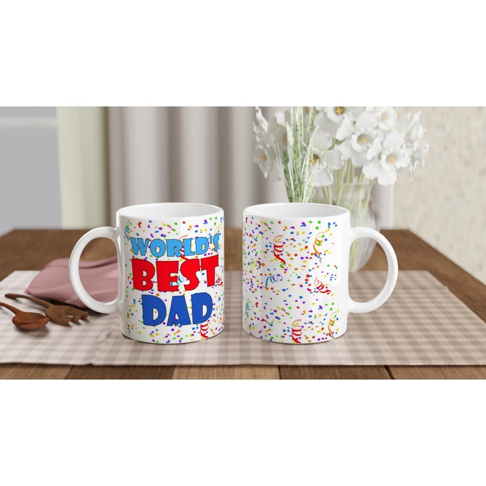 The front and back view of a white ceramic mug with the words, "world's best dad" in blue and red and multicoloured rainbow confetti in the background