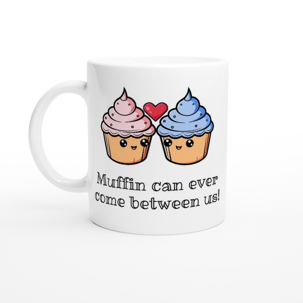 A white ceramic mug with black text saying, "Muffin can ever come between us!" and a picture of a pink iced muffin next to a blue iced muffin and a red heart between them.