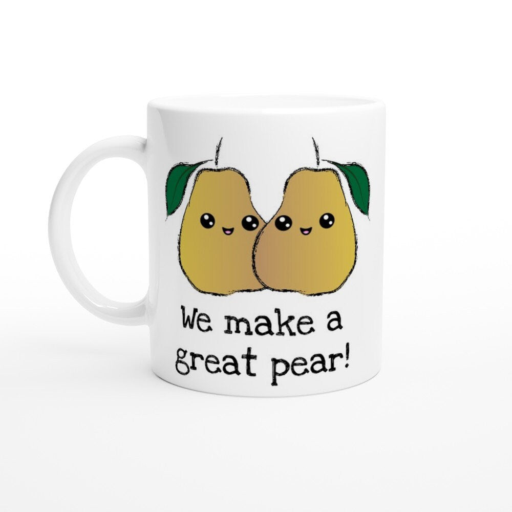 A white ceramic mug the black text saying, "we make a freat pear!" and a picture of two pears next to each other, smiling