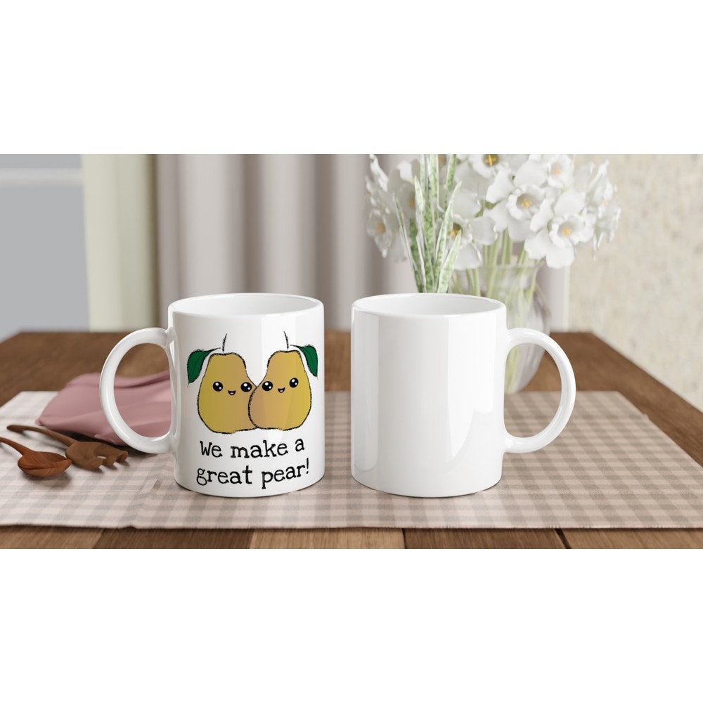 The front and back view of a white ceramic mug the black text saying, "we make a freat pear!" and a picture of two pears next to each other, smiling