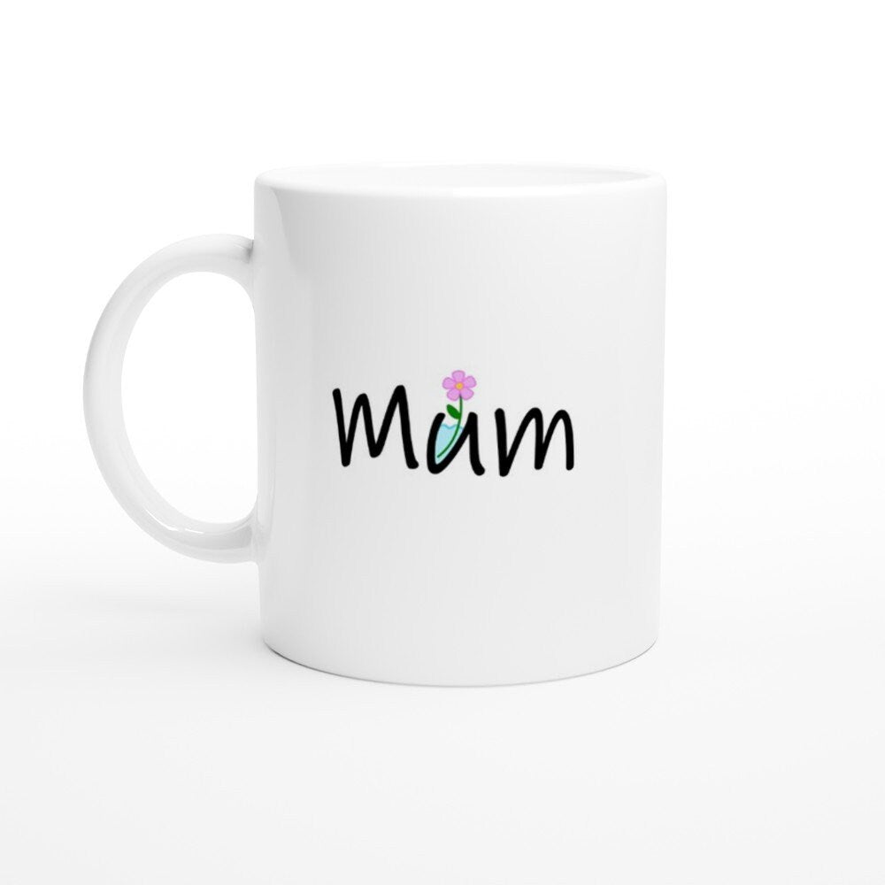 A white ceramic mug with the word, "Mum" written on it in black where the letter "U" is a container with water in it and a pink flower sticking out.