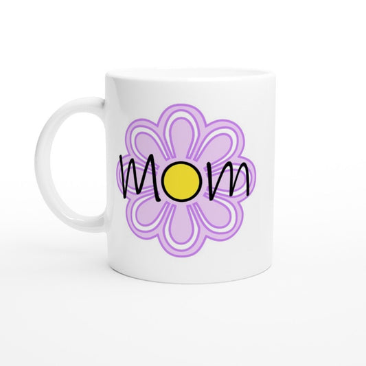 A white ceramic mug with the words "Mom" printed on it in black and a large purple flower in the background.