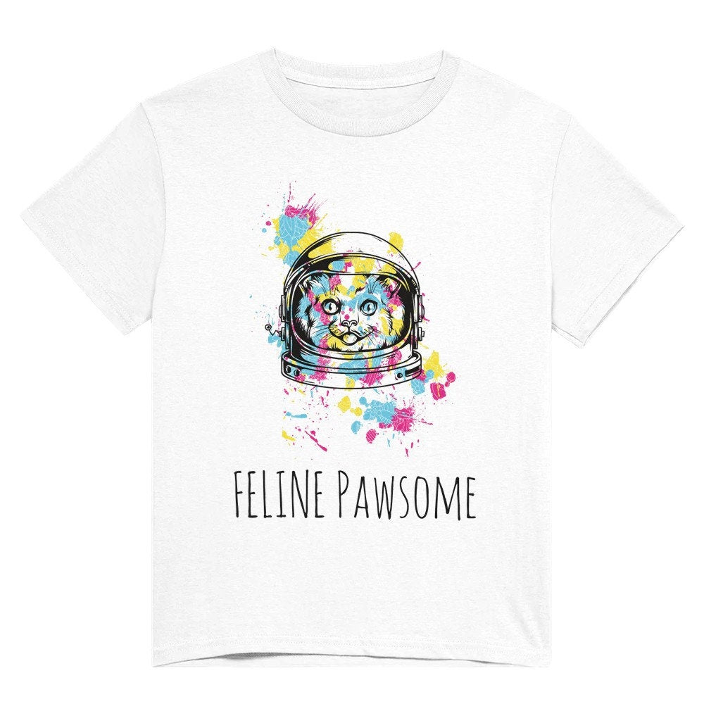 White shirt with the words "feline pawsome" in black and a line drawing of an astronaught cat, splattered with blotches of yellow, blue and pink.